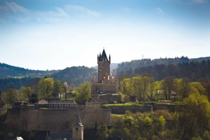 Historischer Wilhelmsturm auf dem Schlossberg in Dillenburg mit Festungsmauern und bewaldeten Hügeln